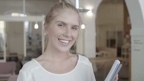 happy beautiful fair haired young woman holding documents