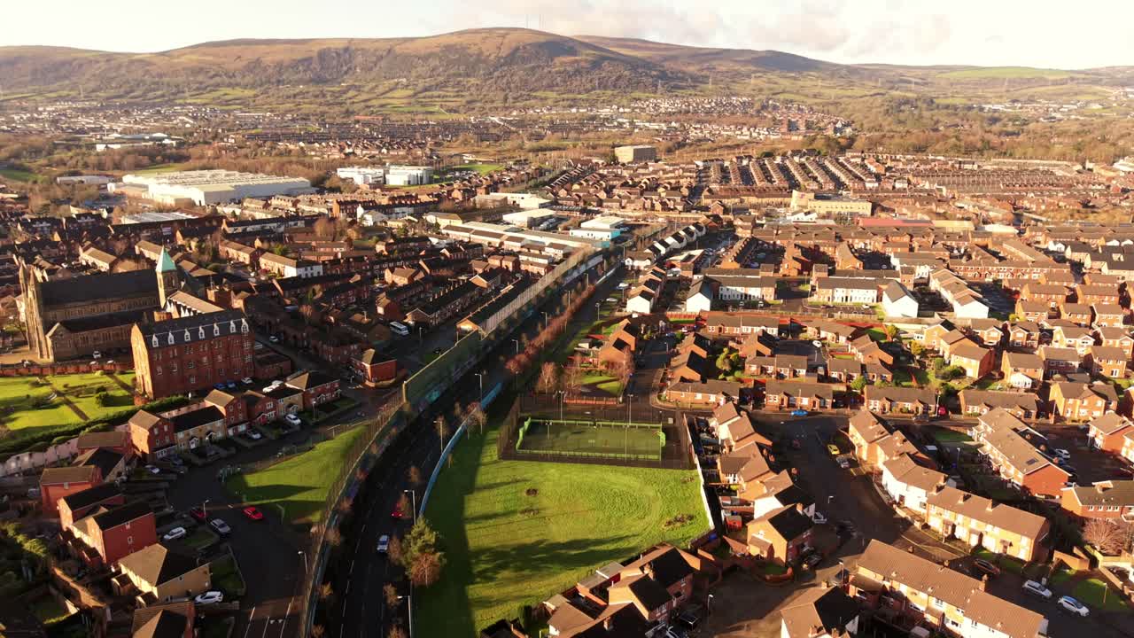 Video aereo ultra-wide 4K a 60 FPS del Belfast Peace Wall Interface a Belfast, Irlanda del Nord. I murales esplorano la politica dell'Irlanda del Nord e del mondo. Prodotto con colore Rec709