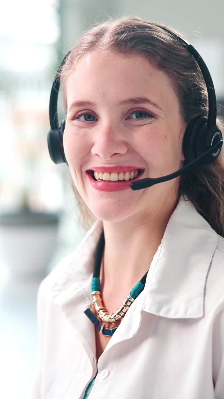 Smilende ung kvinne med headset på kontoret