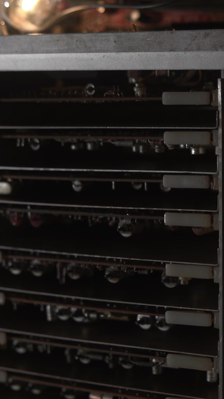 Nærbillede af mining rig-rack med glødende pærer, hardwarekabler og støvede GPU'er i varmt ravfarvet lys, vedligeholdelse