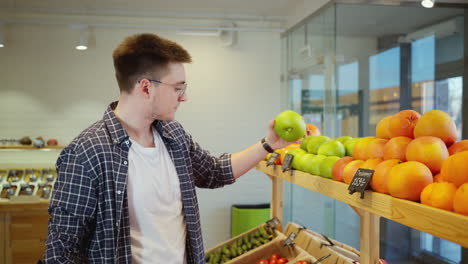 man shopping for fruit at a grocery store