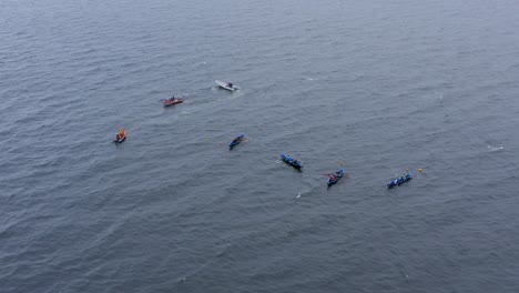 static aerial view of currach boats above buoys in open ocean water