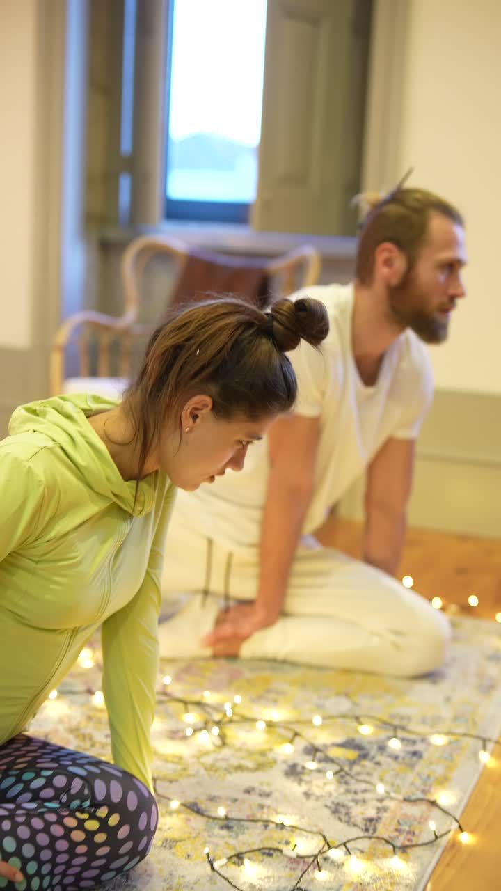 pareja relajándose y estirándose en casa con luces de navidad