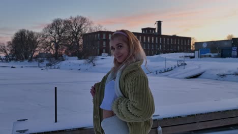 slow motion women looking at camera on winter day with sunset in background