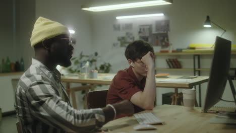 two colleagues collaborating at a desk in an office