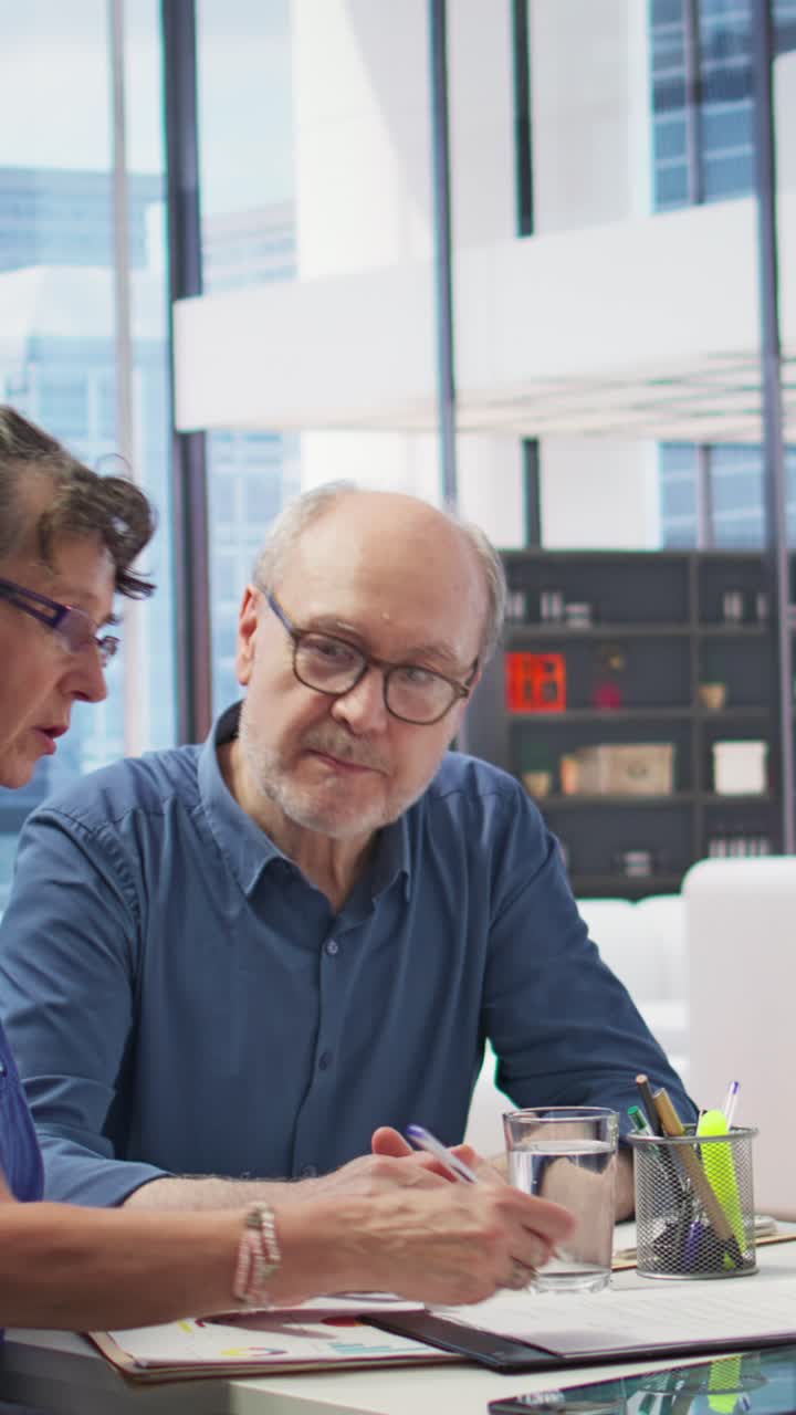 Vertical Video Middle aged couple explores life insurance contract terms with financial adviser