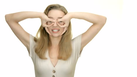 mujer amable haciendo gafas falsas con las manos y riéndose