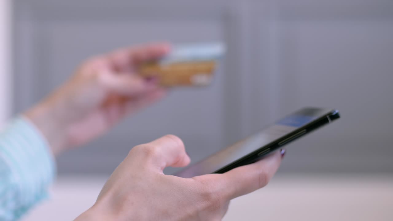mujer usando teléfono inteligente y tarjeta de crédito para comprar en línea - vista lateral de cerca