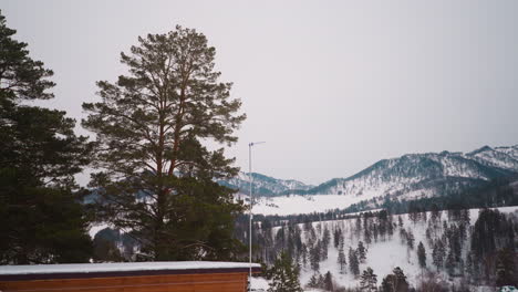 Small-house-roof-against-giant-forestry-mountains-and-hills