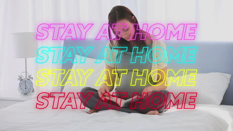 neon "stay at home" sign over pregnant woman reading, promoting covid-19 isolation.