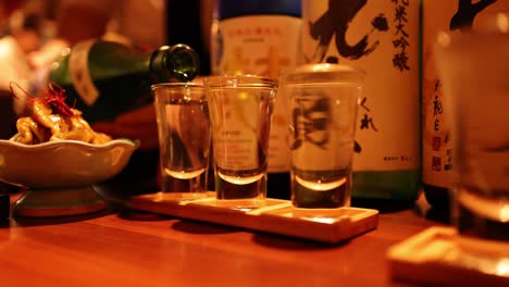 sequential sake pouring into glass at a bar