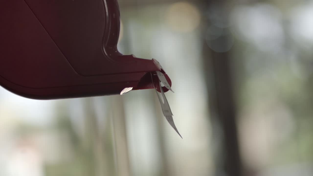 고객은 은행에서 자신의 차례를 기다리는 자동판매기에서 티켓을 꺼니다.