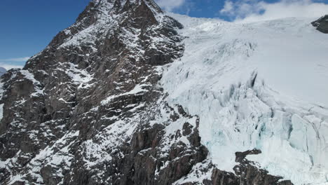 vista aérea de las grietas al borde de un gran glaciar en un día soleado en invierno en los alpes
