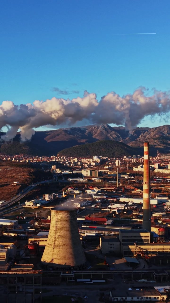 Céu limpo sobre uma área industrial com fumaça saindo de chaminés