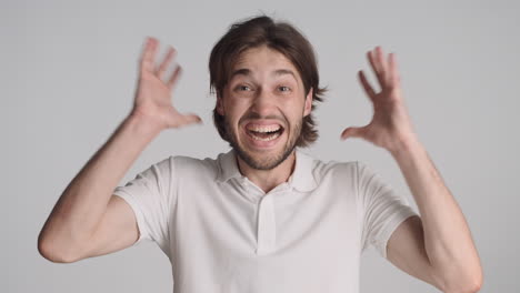 caucasian surprised man in front of camera on gray background.