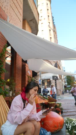 woman using phone outdoors at a cafe