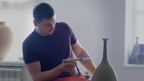Pottery Artist Firing a Vase with a Torch
