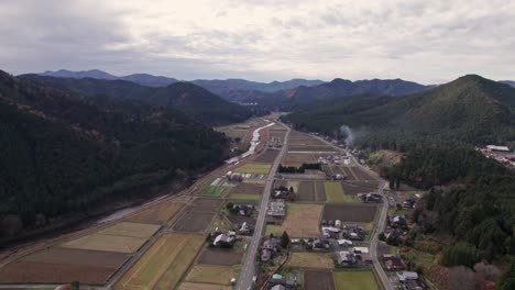 farmland houses of north kyoto, drone fly between agricultural village hills sky background landscape of keihoku