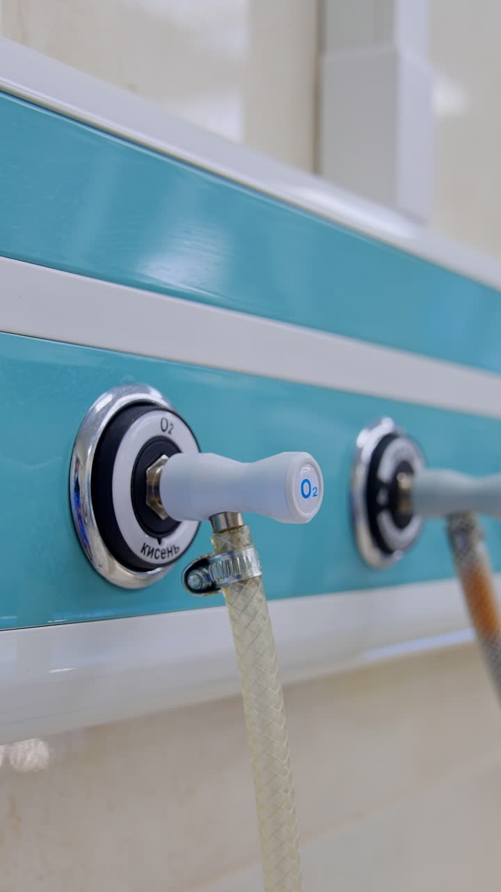 Panel with connected wires on the wall of surgical room. Close up. Blurred backdrop with other equipment in operational theatre. Vertical video