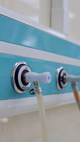 panel with connected wires on the wall of surgical room. close up. blurred backdrop with other equipment in operational theatre. vertical video