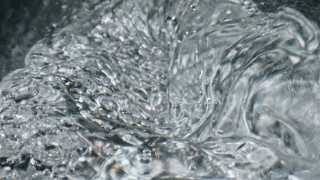 closeup bubbling aqua texture. cold water swirling inside glassware top view