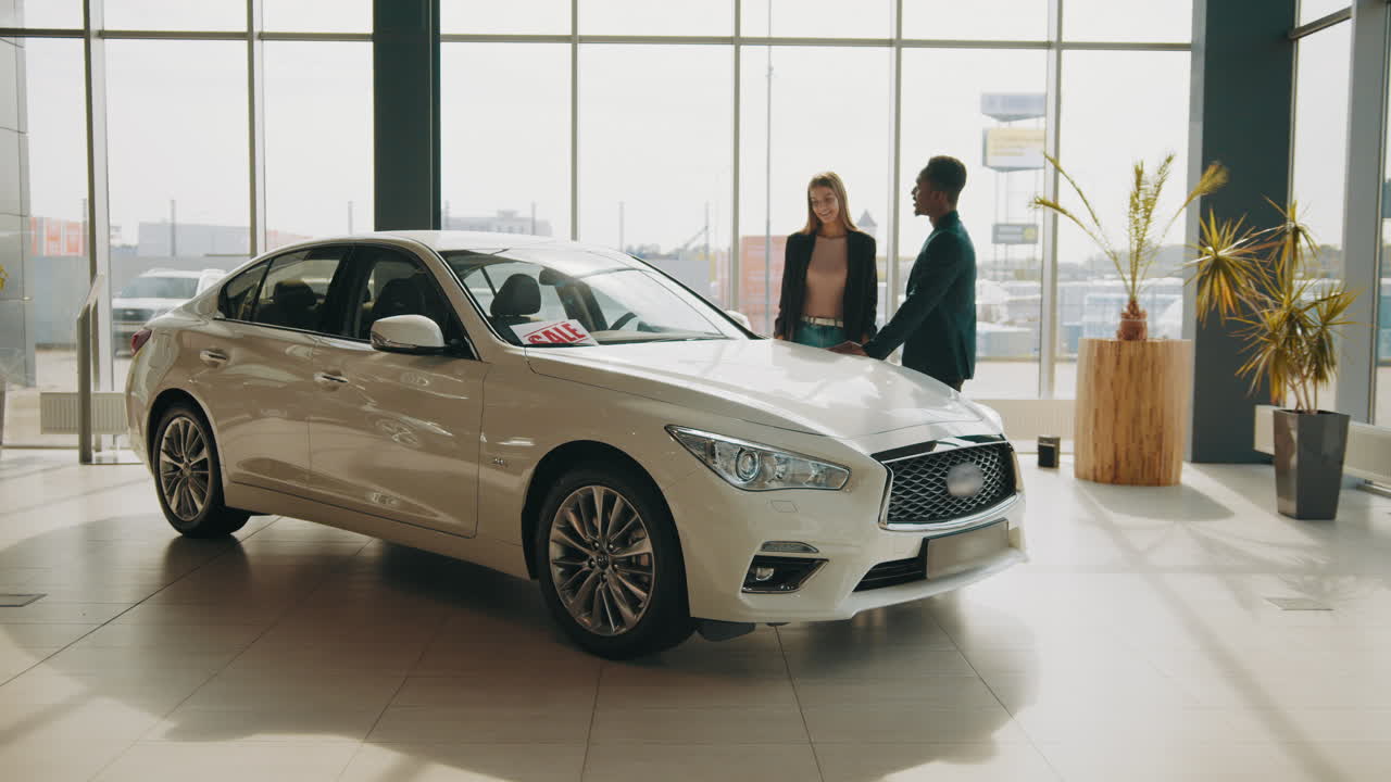 pareja mirando un coche para la venta en un concesionario