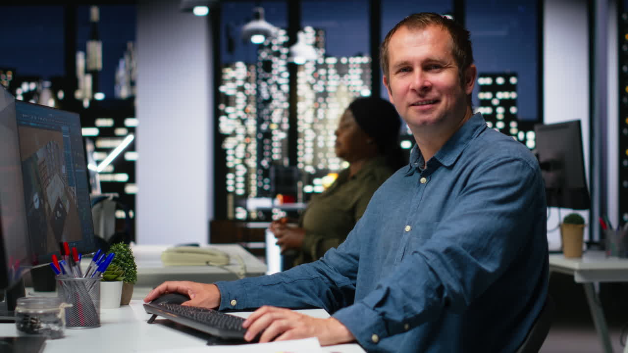 Portrait of male engineer uses architectural software and blueprints