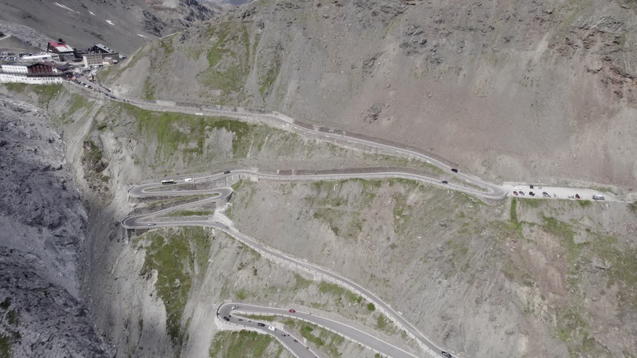 video con drone plano inicial, inversión descriptiva con plano cenital finalizando en la subida del stelvio pass con un horizonte con nevados