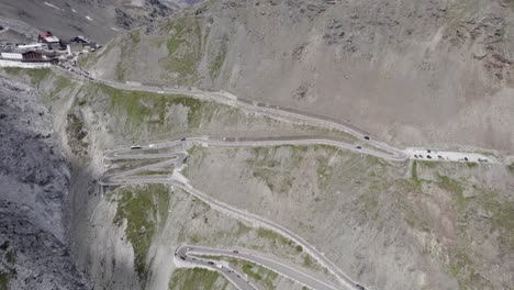 Video-Mit-Drohne-Anfangsflugzeug,-Beschreibende-Umkehrung-Mit-Flugzeugzentralende-Auf-Dem-Anstieg-Des-Stelvio-Passes-Mit-Einem-Horizont-Mit-Schneebedeckten-Bergen