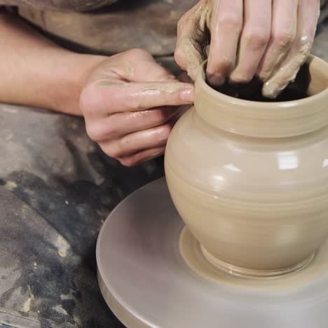 the hands of a potter make a jug on a potter's wheel 3