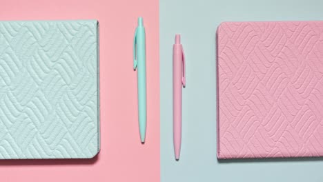stop motion of pastel notebooks and matching pens on a pink and blue split set, loopable and symmetric