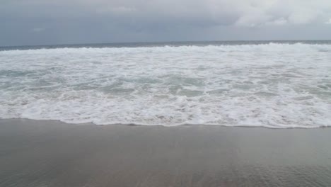 onde schiumose che si infrangono sulla spiaggia