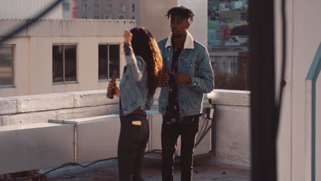 happy young multiracial couple dancing on rooftop at sunset celebrating relationship having fun enjoying playful dance party together