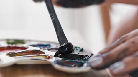 Woman-artist-takes-blue-paint-with-brush-from-white-palette