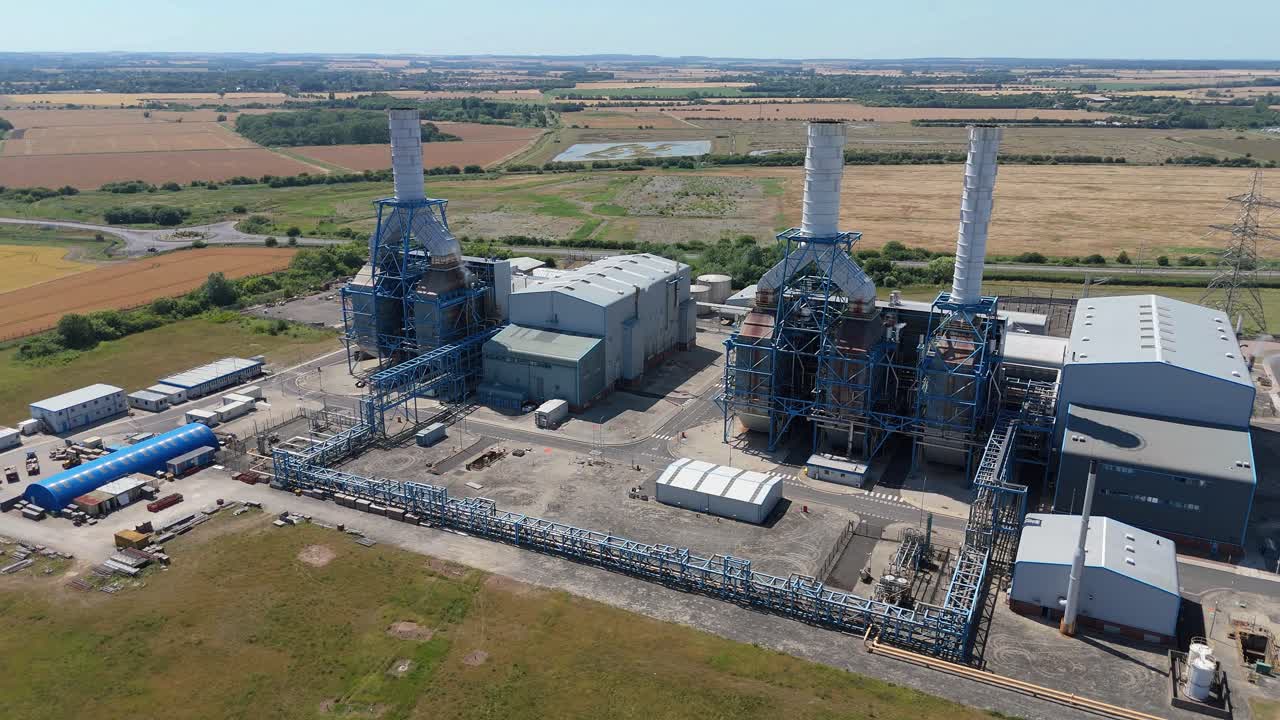 Cinematic drone view of large coal and gas power plant on Humber South Bank with smoke stacks and electrical lines England UK