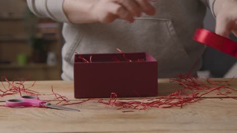 Nahaufnahme-Eines-Mannes-Zu-Hause,-Der-Das-Band-Durchschneidet,-Um-Romantische-Valentinsgrüße-In-Geschenkverpackung-Zu-Verpacken