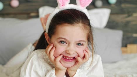 Close-up-of-smiling-child-lying-on-the-bed