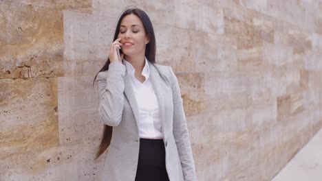 Linda-Mujer-Hablando-Por-Teléfono-Y-Apoyándose-En-La-Pared