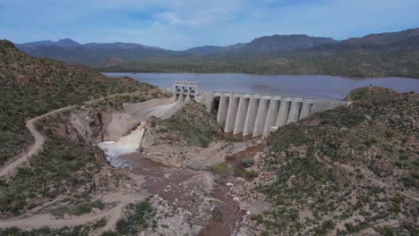 Presa-Que-Libera-Agua-A-Principios-De-Primavera,-Lago-Y-Montañas-Al-Fondo,-Presa-Bartlett-En-Arizona