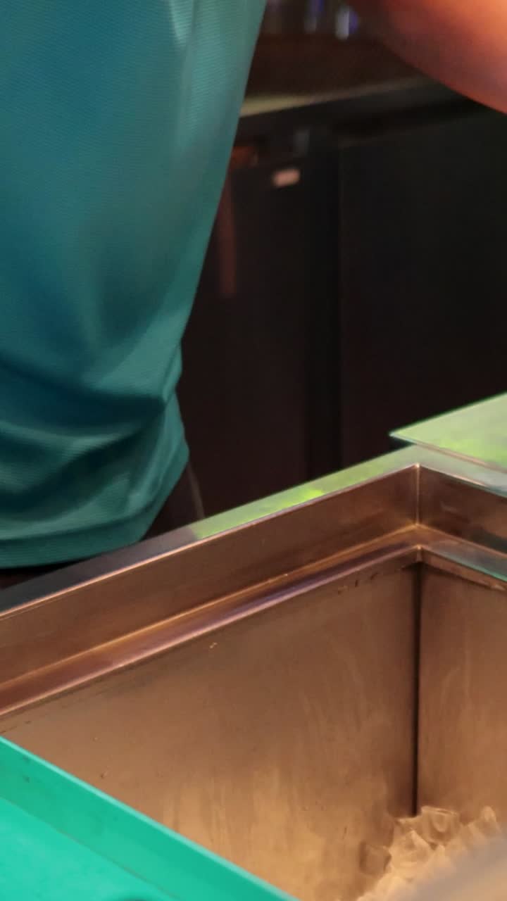 el camarero llena el cubo de hielo en el bar del campo de entrenamiento.