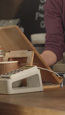 woman paying for coffee using contactless