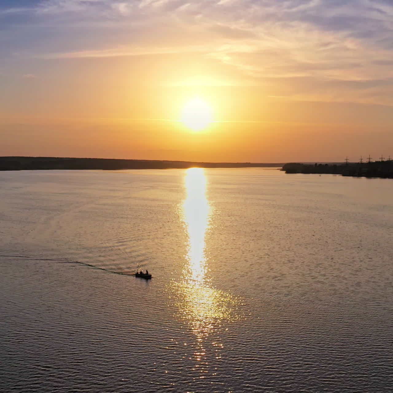 Beautiful sunset is reflecting in the river. Sunset lake landscape. Colorful sky. Nature and water. Plant with smoking pipes on the riverbank.