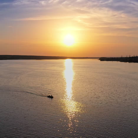 Beautiful sunset is reflecting in the river. Sunset lake landscape. Colorful sky. Nature and water. Plant with smoking pipes on the riverbank.