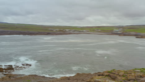 Dynamic aerial pan revealing Doolin coastline from Crab island on an overcast day