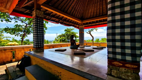 person meditating in a traditional gazebo with scenic bali views in the background