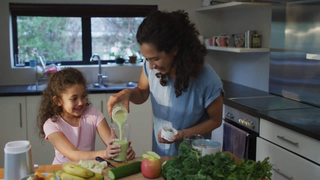 Mère et fille métisses cuisinant ensemble dans la cuisine