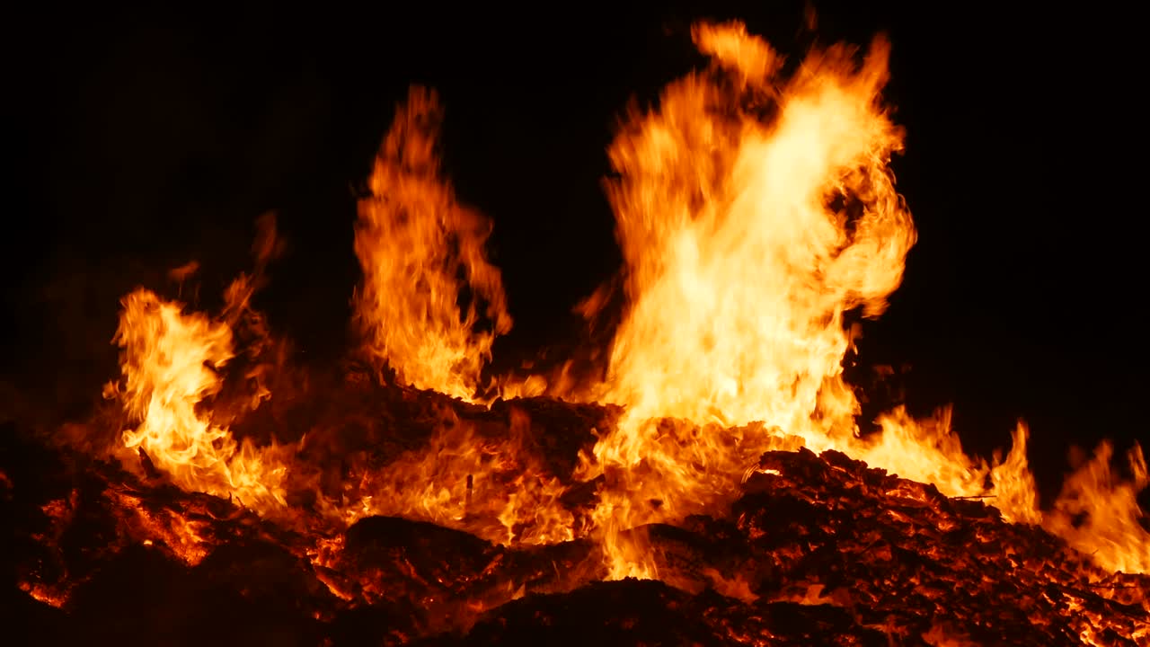 Close-up of real flame of a huge fire the camera approaches very close to the center of the fire and smoothly moves back