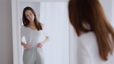 woman trying on clothes in front of a mirror