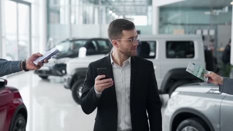 hombre de negocios guapo con teléfono inteligente obtiene dinero rápido
