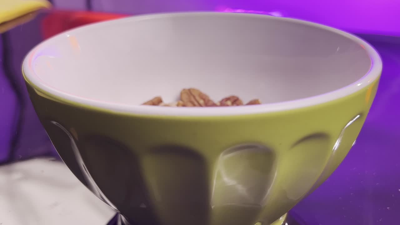 Green bowl with a clean interior, dropping nutz into them